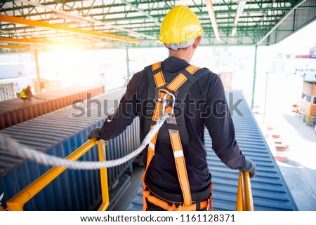 Construction worker use safety harness and safety line working on a new construction site project. Royalty-Free Stock Photo #1161128371