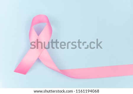 Pink ribbon symbol for breast cancer awareness concept on blue background with copy space for text, logo or wordings insertion or decoration