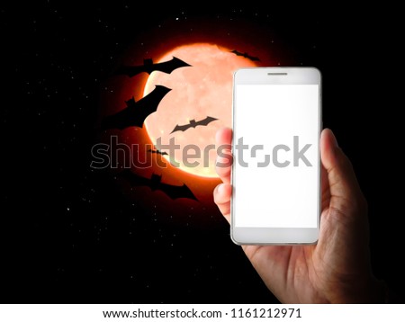 hand on mobile smartphone with white screen for presentation and red moon halloween background
