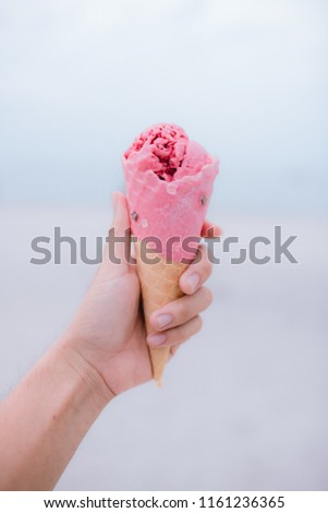 Holding ice cream - ice cream cone on sea