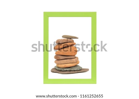 Stone stack in green picture frame isolated on white background