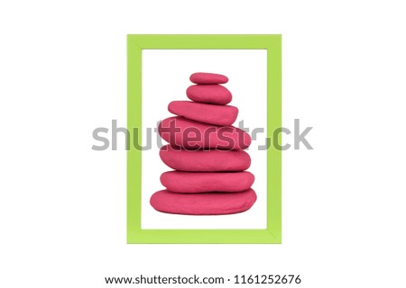 Stone stack in green picture frame isolated on white background
