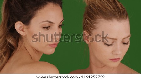 Close up of two young women posing for beauty shot on green screen
