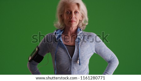 Serious looking old white woman posing in sportswear on green scree