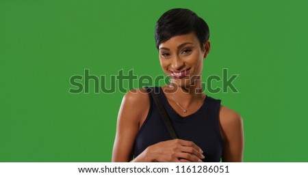 Portrait of pretty young black woman smiling at camera on green screen