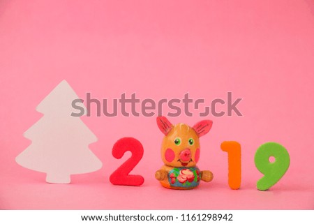 Christmas composition on a pink background, piggy symbol of the year