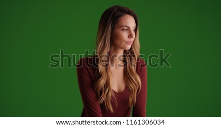 Pensive Caucasian millennial female looking offscreen on green screen