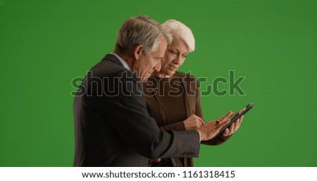 Business team going over financial data on tablet in the hallway on green screen
