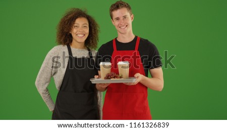 Portrait of two waiters with tray of food and drinks smiling on green screen