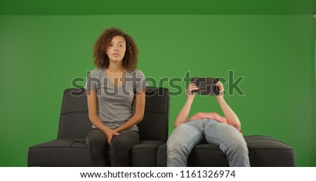 Caucasian male using tablet computer ignoring girlfriend on green screen