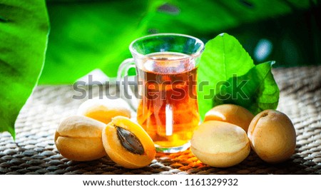 Fruits tea made from Аpricots , organic tea , fresh apricots  fruits whole and half on a natural tropical background.
