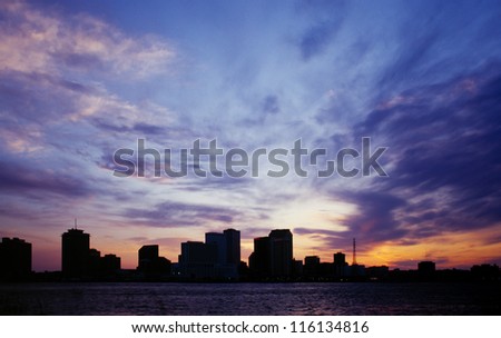 New Orleans city skyline silhouetted against a blue sunset