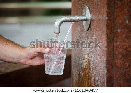 A man is picking up healing water in a glass in Kudowa Zdroj in Poland Royalty-Free Stock Photo #1161348439