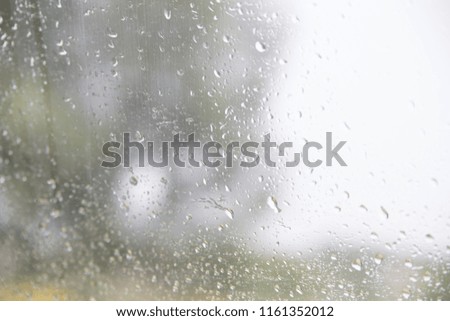Drops of rain on green glass background. Blurred summer abstract backdrop. Selective focus. 