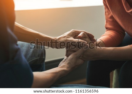 PTSD Mental health concept, Psychologist sitting and touch hand young depressed asian woman for encouragement near window with low light environment.Selective focus. Royalty-Free Stock Photo #1161356596
