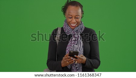 Senior African-American woman uses her phone on green screen