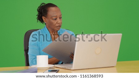 African American businesswoman using her laptop at her desk on green screen