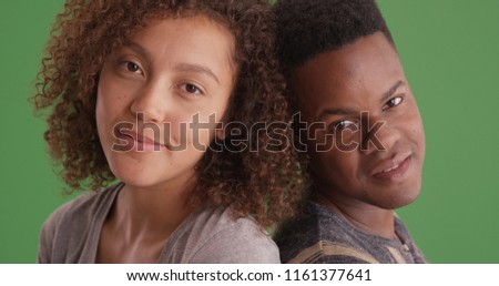Happy smiling African American man and woman lean on each other on green screen