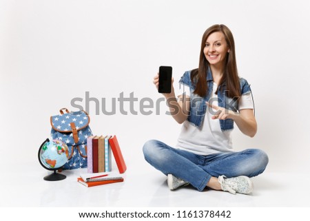Young woman student pointing index finger on mobile phone with blank black empty screen near globe, backpack, school books isolated on white background. Education in high school university college