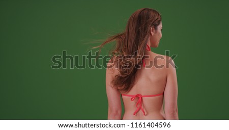 Rear view of attractive woman in bikini with back to camera on green screen