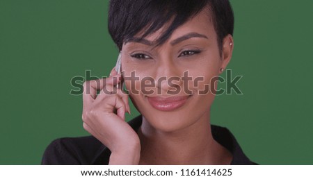 Happy smiling black woman talking on mobile phone on green screen