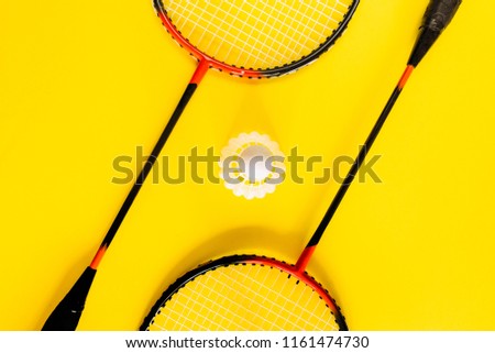 Volant and racket, badminton on yellow background. Concept excitement, resistance, competition. Pop Art Minimalism