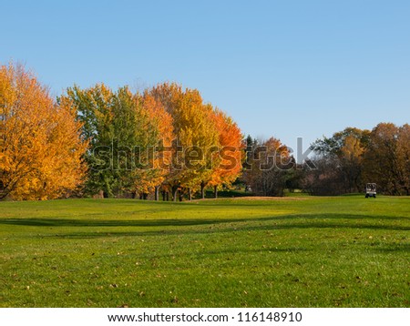 Golf in fall with cart on the fairway