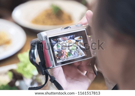A young woman taking Camera of food 