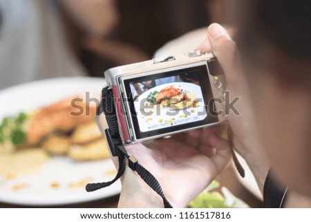 A young woman taking Camera of food 