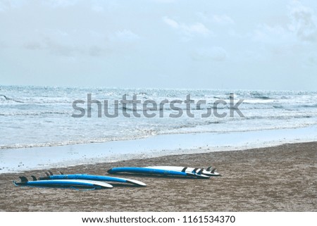 Multi Surfboard on clear sand beach with copy space for content