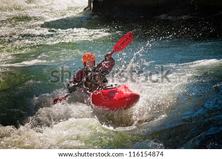 Running the dangerous mountain river in a kayak. Royalty-Free Stock Photo #116154874