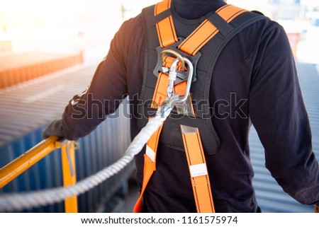 Construction worker use safety harness and safety line working on a new construction site project. Royalty-Free Stock Photo #1161575974