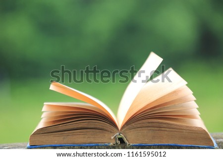 Close-up image of old book opened on a garden floor natural green is the background  selective focus and shallow depth of field