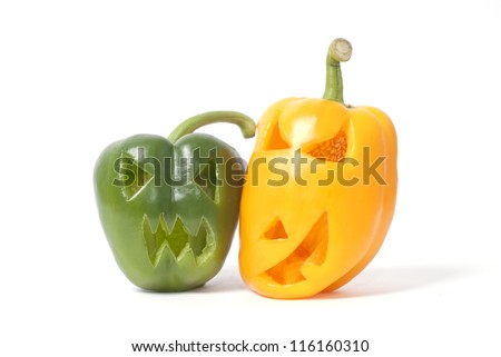Halloween faces carved into yellow and green capsicum vegetables instead of pumpkin forming special jack o lanterns.