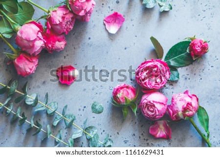 Pink roses on a grey background. Flat lay flowers composition, top view.