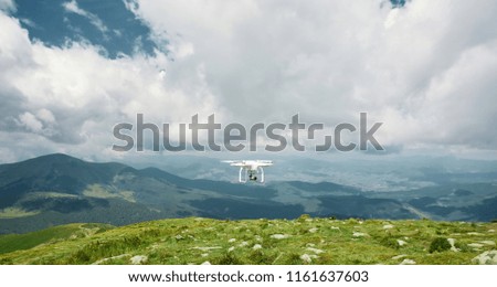 drone quadcopter with digital camera in the mountains. The drone with camera takes pictures of the misty mountains. quadcopter drone flying with digital camera on the sky.