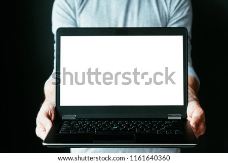 online investment. stock or cryptocurrency trading. making money on the internet. man holding a laptop with empty white screen.