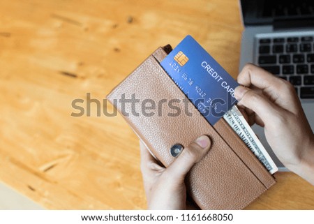 Woman shopping online and paying with a credit card  from the wallet. Copy space.