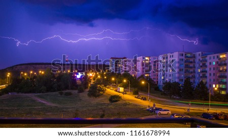 Beautiful flash of lightning storm above the housing estates over city, Brno, Lisen, Houbalova, Czech Republic. Amazing Blue color background HD. Perfect Wallpaper 4k. Thunderstorm.