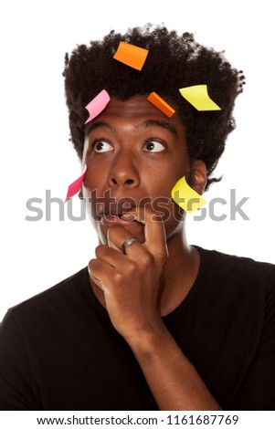 Confused young african man with stickers on his head on white background