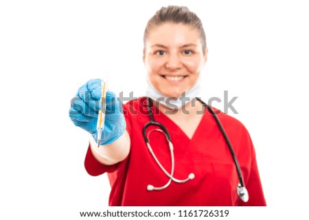 Selective focus of young medical nurse wearing red scrub showing thermometer isolated on white background with copyspace advertising area