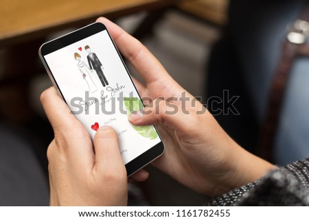 mobile design concept: girl using a digital generated phone with wedding invitation online on the screen. All screen graphics are made up.