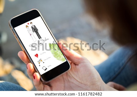 close-up view of young woman checking wedding website her mobile phone. All screen graphics are made up.
