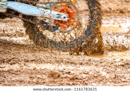Detail of motocross mx bike spinning in heavy mud during race