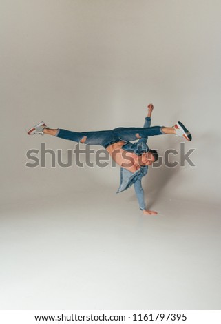 shot of jump feet up, of mad, crazy, cheerful, successful, lucky guy in casual outfit, jeans, jumping with hands up,triumphant, gesturing against white background
