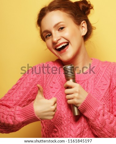 life style, happiness, emotional and people concept:   girl with a microphone singing and having fun