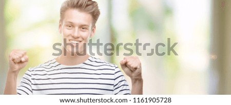 Young handsome blond man wearing stripes sailor t-shirt screaming proud and celebrating victory and success very excited, cheering emotion