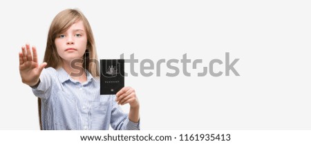 Young blonde toddler holding australian passport with open hand doing stop sign with serious and confident expression, defense gesture