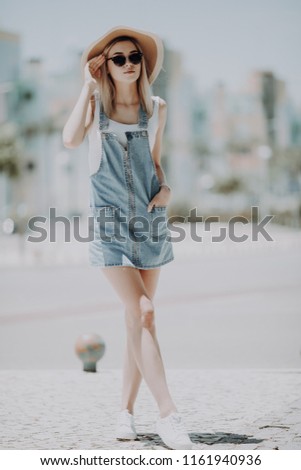 Beautiful young woman wearing dress and walking on the street