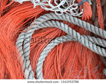 background of white ropes and orange fibers from a fishing boat, the net can be seen on top of the picture